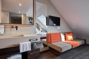 a bathroom with a couch and a sink in a room at Hotel GIO in Munich