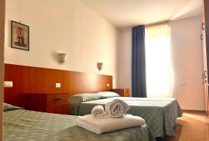 una camera d'albergo con due letti e asciugamani di Nazareth Residence a Viterbo