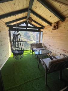 um quarto com cadeiras e um baloiço numa cabana em Yamacda Suit Otel em Çamlıhemşin