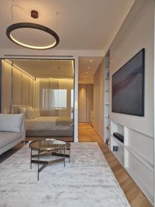 ein Wohnzimmer mit einem Sofa und einem TV in der Unterkunft Luxurious accommodation on the Grand Prix track in Monte Carlo