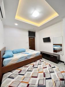um quarto com uma cama grande e uma televisão em Wisma Selma Garuda em Kejayan