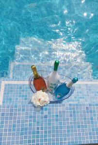 a glass bowl with bottles and flowers next to a swimming pool at La Păstrăvărie in Mehadia