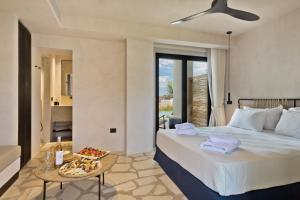 a bedroom with a bed and a table with a tray of food at Almi Luxury Rooms in Amoopi