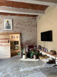 a living room with a tv on a brick wall at 509 Accommodation in Oaxaca City