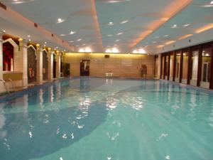 a large swimming pool with blue water in a building at Luoxingge Narada Hotel in Jiashan