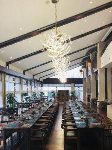 a large dining room with long tables and a chandelier at Luoxingge Narada Hotel in Jiashan