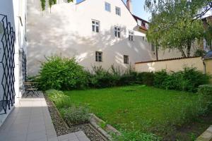 einen Garten vor einem weißen Gebäude in der Unterkunft City Center Apartments in Prag