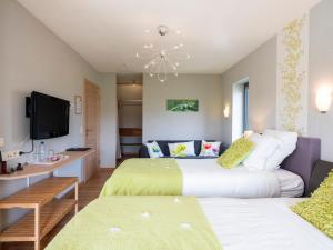 a hotel room with two beds and a tv at B&B La Chabetaine in Morhet