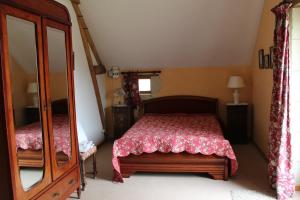 1 dormitorio con cama y espejo grande en Le prieure, en Raslay