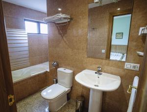 a bathroom with a toilet and a sink and a tub at Hospedería Puerta de la Catedral in Ciudad-Rodrigo
