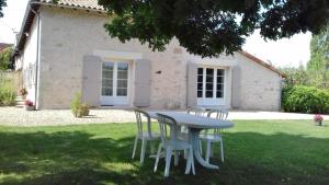 a table and chairs in front of a house at Gîte de says in Champagné-Saint-Hilaire