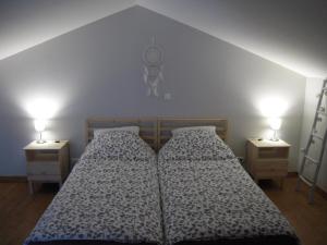 1 dormitorio con 2 camas y 2 luces en la pared en Gite du fournil, en Bouresse
