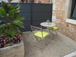 una mesa pequeña y 2 sillas en el patio en Gite du fournil, en Bouresse