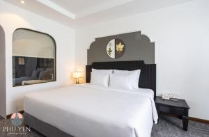 um quarto com uma cama branca e um espelho grande em PHÚ YÊN EVERYDAY HOTEL em Tuy Hoa