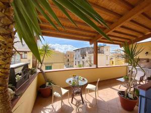 eine Terrasse mit einem Tisch und Stühlen auf dem Balkon in der Unterkunft Solemar Sicilia - Casa Maria in Santa Flavia