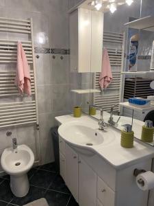 a white bathroom with a sink and a toilet at Apartment Helios - self check in, strict center in Osijek