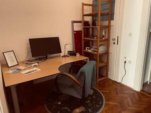 a desk with a computer monitor and a chair at Apartment Helios - self check in, strict center in Osijek
