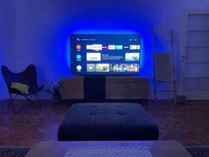 a living room with a large television in a blue room at Apartment Helios - self check in, strict center in Osijek