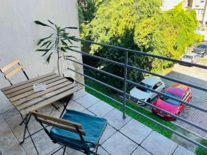 a balcony with a bench and a table and chairs at Apartment Helios - self check in, strict center in Osijek