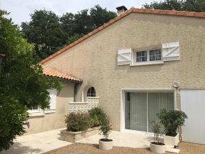 a house with two potted plants in front of it at Séjour à beaubaton in Mignaloux-Beauvoir