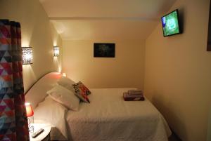 a small room with a bed and a television at Séjour à beaubaton in Mignaloux-Beauvoir