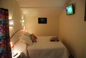 um pequeno quarto com uma cama e uma televisão em Sejour a beaubaton em Mignaloux-Beauvoir