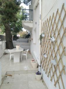 a patio with a table and chairs and a fence at IOKASTI STUDIOS 5 in Andros