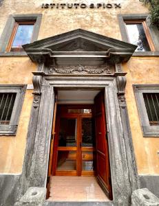 - une entrée pour un bâtiment avec une porte en bois dans l'établissement Nazareth Residence, à Viterbe