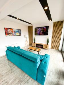 ein Wohnzimmer mit einem blauen Sofa und einem Tisch in der Unterkunft NOVA House Apartments in Delniţa