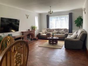 a living room with a couch and a fireplace at Peaceful Home in Guildford Surrey UK -Free Parking, Garden, River & Waterfall in Bramley