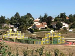 un grupo de estructuras de juego amarillas en un parque en Lilas la vallee des noyers, en Lhommaizé