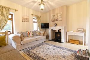 uma sala de estar com um sofá e uma lareira em East Lodge em Bolney