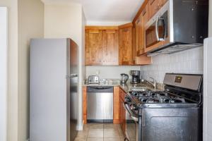 a kitchen with a stove and a refrigerator at Cozy N End 2BR steps from Harborwalk BOS-445 in Boston