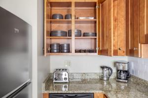 a kitchen with wooden cabinets and a counter top at Cozy N End 2BR steps from Harborwalk BOS-445 in Boston