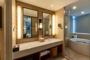 嘉善Luoxingge SSAW Boutiquel Hotel的带水槽、浴缸和镜子的浴室
