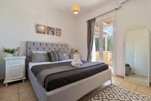 a bedroom with a large bed with a large window at Sea View Villa-Luxury Residence-Nature & Calm in Porto Heli