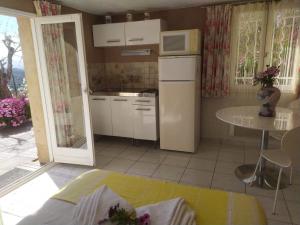 a small kitchen with a table and a microwave at Studio le romantique à 20 kms de Nice in Bendéjun
