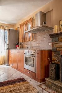 uma cozinha com armários de madeira e um forno com placa de fogão em Stamoulis' house em Drakeia