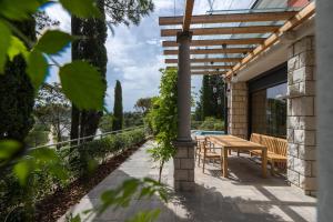 un patio con una mesa de madera y un banco en Vila Laguna Strunjan - Terme Krka en Strunjan