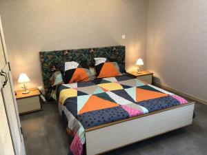 1 dormitorio con 1 cama grande y colcha colorida en La bergerie, 