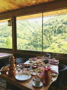 einen Tisch mit Speisen und Bergblick in der Unterkunft Yamacda Suit Otel in Çamlıhemşin