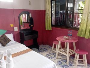 a bedroom with a bed and a table and a piano at Sabaydee House at Pai in Pai