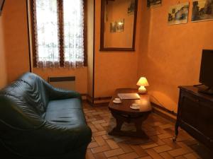 a living room with a couch and a table with a lamp at R-d-t in Martaizé