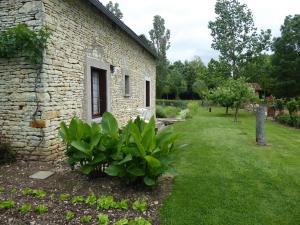 an old stone house with a green yard at R-d-t in Martaizé