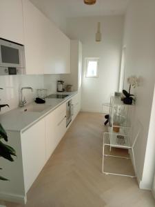 a white kitchen with white cabinets and a sink at Citylux Verdandi in Turku