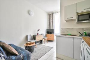 a kitchen and a living room with a couch at Magnificent studio near Paris in Clichy