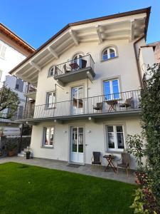 a house with a balcony and a lawn at Garden Lodge in Stresa