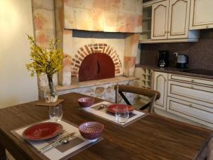 una cucina con tavolo e forno in mattoni di Rive de gartempe a Vicq-sur-Gartempe