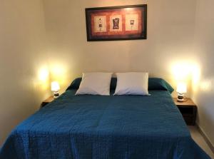 una camera con un letto blu con due lampade di Rive de gartempe a Vicq-sur-Gartempe