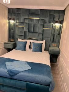 een slaapkamer met een groot bed met blauwe kussens bij Miriam Studio in Boekarest
